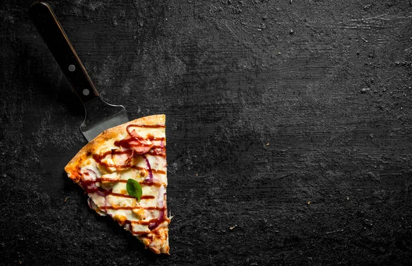 Bir parça kokulu barbekü pizzası. Siyah rustik arka plan üzerinde