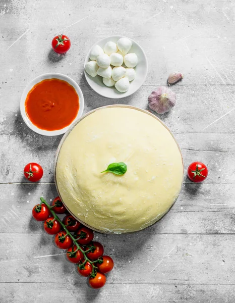 Mozzarella, domates salçası ve kiraz ile hamur. Beyaz ahşap arka plan üzerinde