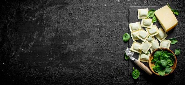 Ravioli bir taş Tahta üzerinde sığır eti ile çiğ. Siyah rustik arka plan üzerinde