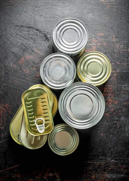 様々な缶の缶詰食品の品揃え 暗い素朴な背景に — ストック写真