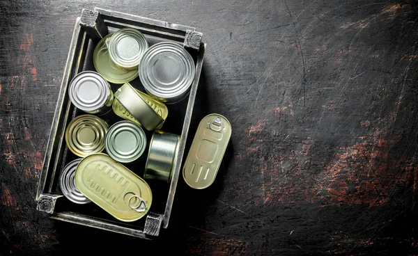 箱に缶詰の食品を含むアルミニウム閉じた缶のグループ 暗い素朴な背景に — ストック写真