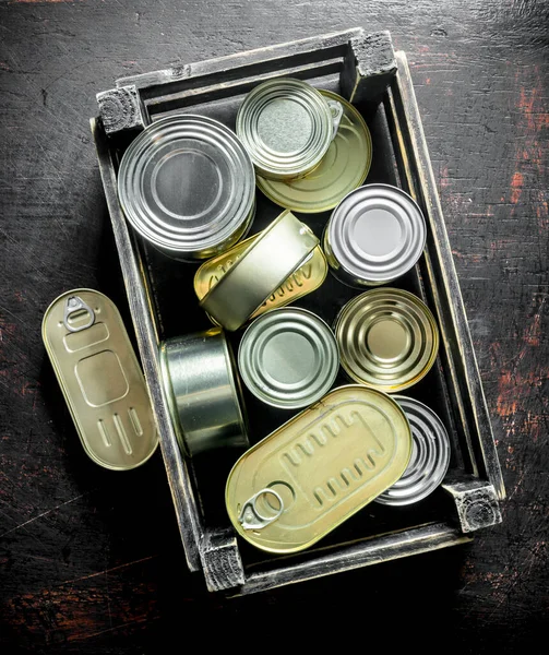 箱に缶詰の食品を含むアルミニウム閉じた缶のグループ 暗い素朴な背景に — ストック写真