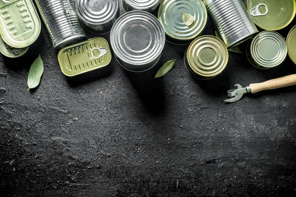 缶詰の食品とスズ缶の異なる種類のセット 黒い素朴な背景に — ストック写真