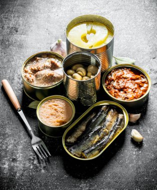 Konserve yiyecek konserveleri farklı türde ayarlayın. Koyu rustik arka plan üzerinde