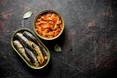 Açık kantlarda konserve balık. Koyu rustik arka plan üzerinde