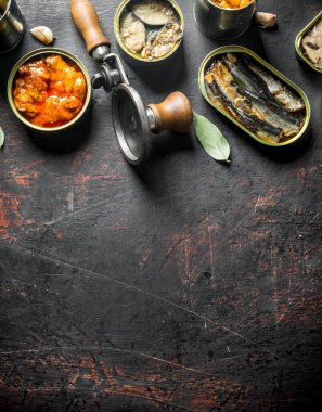 Konserve gıda ile farklı konserve konserve grubu. Koyu rustik arka plan üzerinde