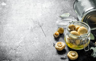 Cam bir kavanozda konserve mantar. Koyu rustik arka plan üzerinde