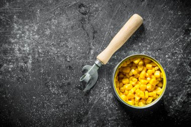 Konserve mısır ile açık konserve. Koyu rustik arka plan üzerinde