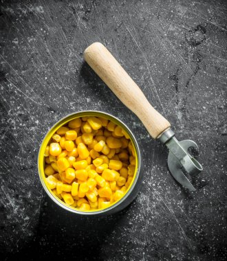 Konserve mısır ile açık konserve. Koyu rustik arka plan üzerinde