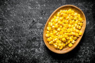 Tabakta konserve mısır. Koyu rustik arka plan üzerinde