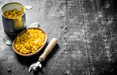 Bir tabakta ve Bay yaprağı olan bir konserve mısır. Koyu rustik arka plan üzerinde