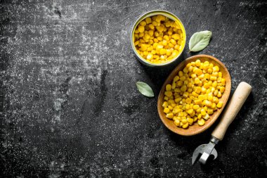 Bir tabakta ve Bay yaprağı olan bir konserve mısır. Koyu rustik arka plan üzerinde