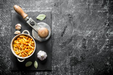 Sarımsak ve Defne yaprağı ile bir taş Tahta üzerinde bal agaric turşusu. Koyu rustik arka plan üzerinde