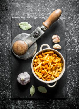 Sarımsak ve Defne yaprağı ile bir taş Tahta üzerinde bal agaric turşusu. Koyu rustik arka plan üzerinde