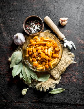 Bay yapraklarıeski bir çanta üzerinde mantar turşusu. Koyu rustik arka plan üzerinde