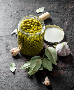 Yeşil bezelye ile açık cam kavanoz. Koyu rustik arka plan üzerinde