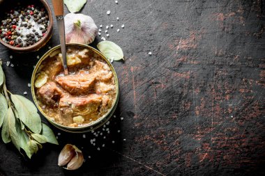 Sarımsak, baharat ve Defne yaprağı ile bir konserve et. Koyu rustik arka plan üzerinde