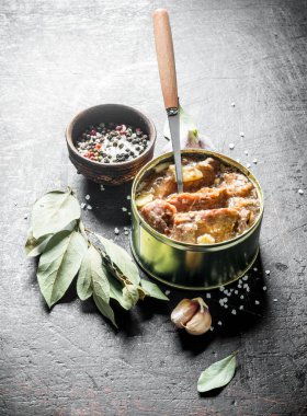 Sarımsak, baharat ve Defne yaprağı ile bir konserve et. Koyu rustik arka plan üzerinde