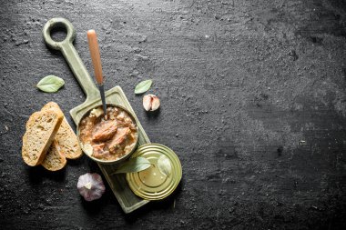 Kesme Tahtasıüzerinde konserve et açık. Siyah rustik arka plan üzerinde