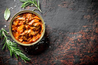 Biberiye ile domates soslu sprat. Koyu rustik arka plan üzerinde