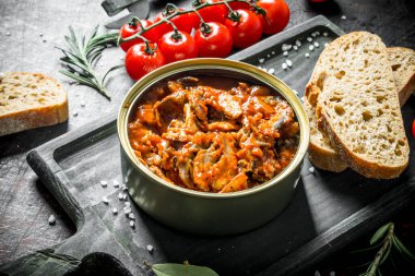 Ekmek, kiraz domates ve biberiye ile domates soslu sprat. Koyu rustik arka plan üzerinde