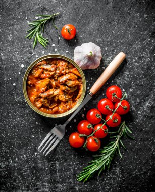 Sarımsak, kiraz domates ve biberiye ile bir konserve konserve domates sosu içinde Sprat. Koyu rustik arka plan üzerinde