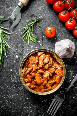 Domates soslu sprat ile açık konserve konserve. Koyu rustik arka plan üzerinde