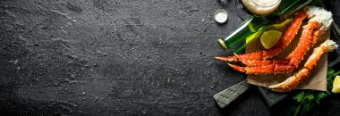 Bira ve limonla kağıt üzerinde yengeç. Siyah rustik arka plan üzerinde