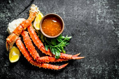 Soslu yengeç, otlar ve limon. Koyu rustik arka plan üzerinde
