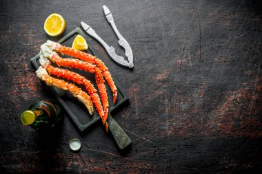 Bir şişe bira ve limon dilimleri yle kesme tahtasında yengeç. Koyu rustik arka plan üzerinde