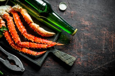 Biralı kesme tahtasında yengeç. Koyu rustik arka plan üzerinde