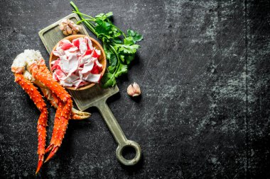 Yengeç eti ve taze yengeç yeşillik ve sarımsak ile kesme Tahtası üzerinde. Koyu rustik arka plan üzerinde