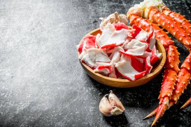 Tabakta yengeç eti ve sarımsak karanfilli taze yengeç. Koyu rustik arka plan üzerinde