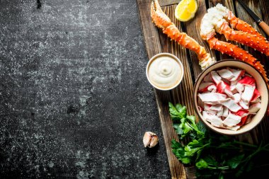 Yengeç eti ve taze yengeç tepside sos, limon dilimleri ve maydanoz. Koyu rustik arka plan üzerinde