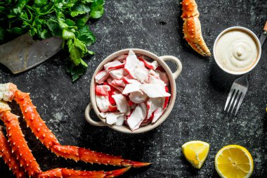 Sos ve maydanoz ile kasede yengeç eti. Koyu rustik arka plan üzerinde