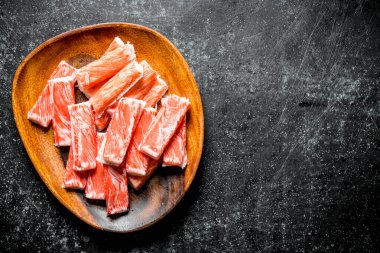 Yengeç tahta bir tabağa yapışır. Koyu rustik arka plan üzerinde