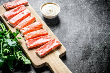 Yengeç sos ve maydanoz ile kesme Tahtası üzerinde sopalarla. Koyu rustik arka plan üzerinde