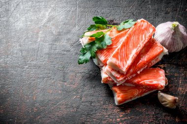 Yengeç sarımsak ve maydanozla yapışır. Koyu rustik arka plan üzerinde