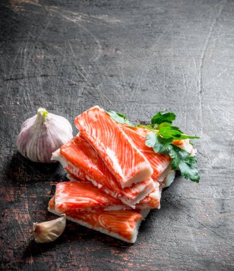 Yengeç sarımsak ve maydanozla yapışır. Koyu rustik arka plan üzerinde