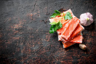 Yengeç sarımsak ve maydanozla yapışır. Koyu rustik arka plan üzerinde