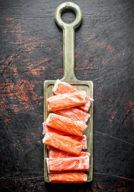 Yengeç kesme tahtasına yapışır. Koyu rustik arka plan üzerinde