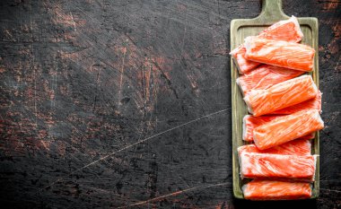 Yengeç kesme tahtasına yapışır. Koyu rustik arka plan üzerinde