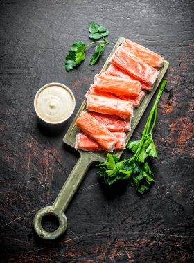 Yengeç sos ve maydanoz ile kesme Tahtası üzerinde sopalarla. Koyu rustik arka plan üzerinde