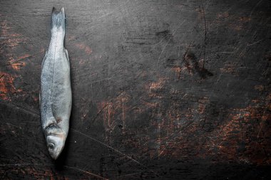 Taze balık levreği çiğ. Koyu rustik arka plan üzerinde