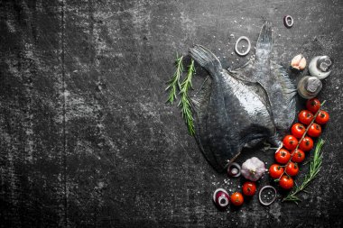 Biberiye, domates ve sarımsak ile çiğ pisi balığı. Koyu rustik arka plan üzerinde