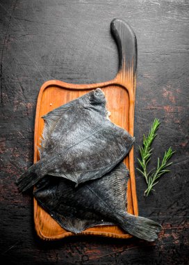 Biberiye ile ahşap doğrama Tahtası üzerinde Taze çiğ balık. Koyu rustik arka plan üzerinde