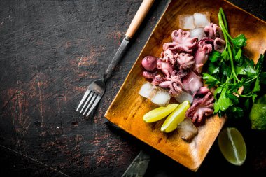 Kireç ve yeşillikli bebek ahtapot. Koyu rustik arka plan üzerinde