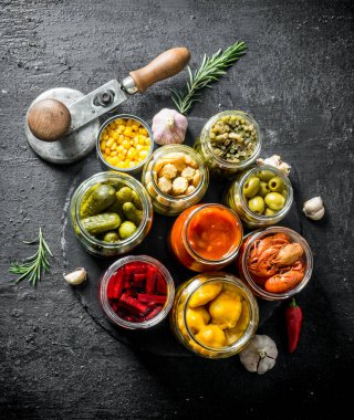 Biberiye ve sarımsak ile bir taş Tahta üzerinde ev yapımı turşu gıda. Siyah rustik arka plan üzerinde