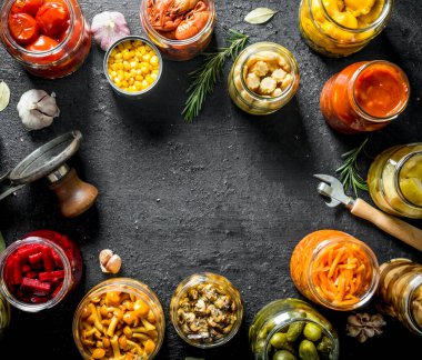 Çeşitli korunmuş gıda kavanoz. Siyah rustik arka plan üzerinde