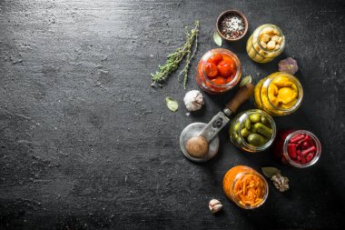 Baharat, kekik ve sarımsak ile çeşitli salamura sebzeler. Siyah rustik arka plan üzerinde